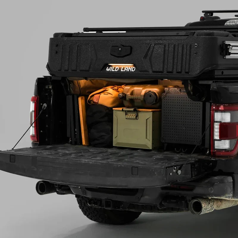 PickupMate WinTopper raised above a pickup bed with organized camping gear